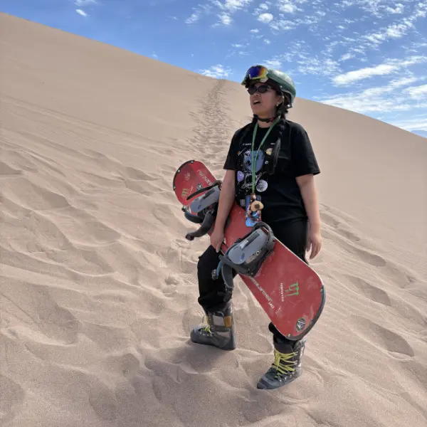 Hiking up sand dune with sandboard Valle de la Muerte Atacama
